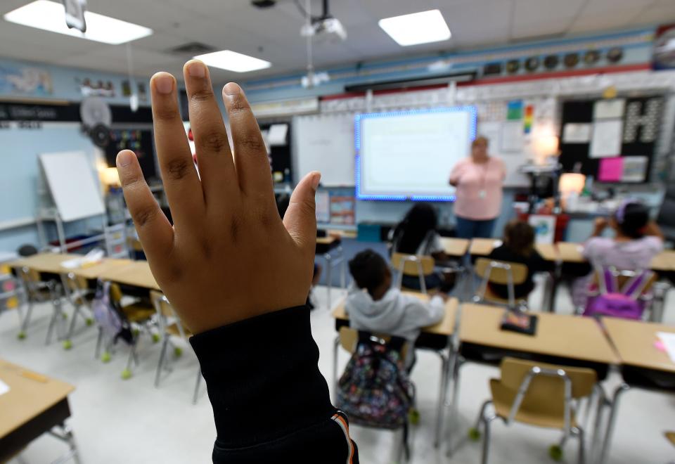 A third grader raises a hand to participate during an English language arts assignment on June 6, 2023, at Dodson Elementary School in Nashville, Tenn. The student was part of Promising Scholars, the Metro Nashville Public Schools summer program.