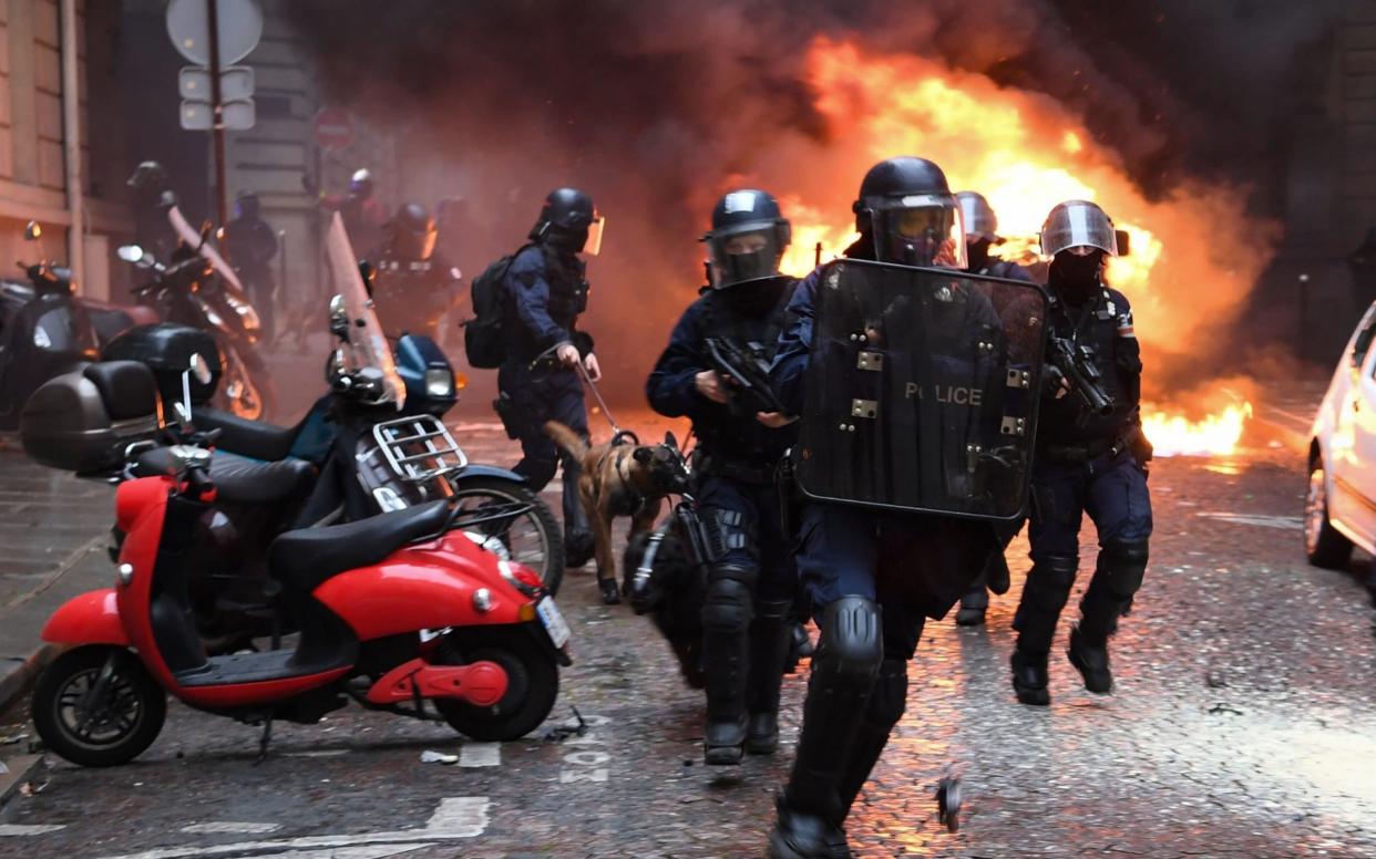 Riot police clash with protestors in Paris on Saturday - AFP