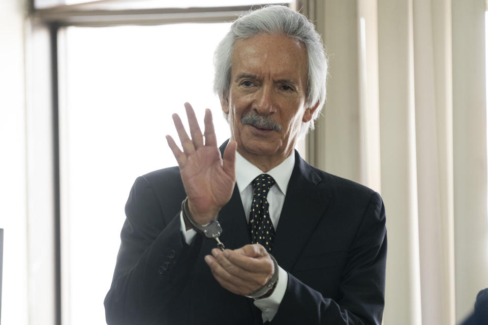 Guatemalan journalist Jose Ruben Zamora, founder of El Periodico newspaper, waves wearing handcuffs as he arrives to court for his hearing in Guatemala City, Wednesday, May 15, 2024. Zamora has been jailed for almost two years and seeks his release. (AP Photo/Moises Castillo)