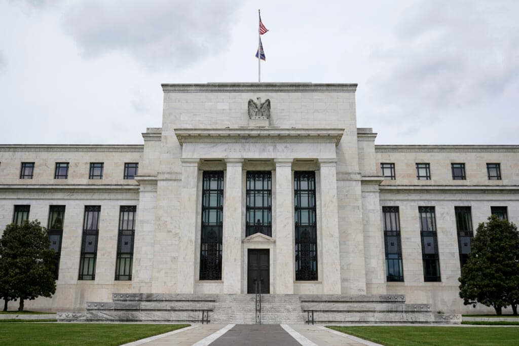 An American flag flies over the Federal Reserve building, Tuesday, May 4, 2021, in Washington. The three major U.S. banking regulators said they plan to encourage lending to the poor and racial minorities in the areas where banks have branches.