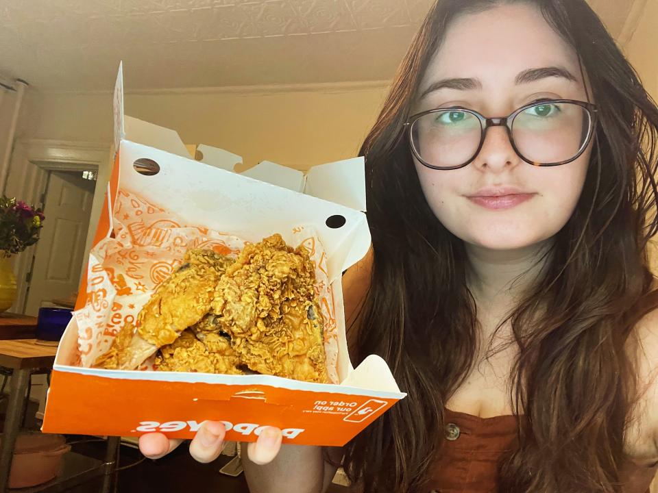 erin mcdowell author holding box of popeyes fried chicken