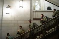 <p>Members of the National Guard walk through the US Capitol in Washington, DC, January 13, 2021</p>