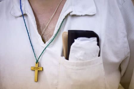 A cross hangs around the neck of an offender at the Southwestern Baptist Theological Seminary inside the Darrington Unit of the Texas Department of Criminal Justice men's prison in Rosharon, Texas August 12, 2014. REUTERS/Adrees Latif