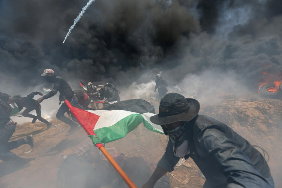 Palestinian demonstrators run for cover from Israeli fire and tear gas at the Israel-Gaza border during a protest against the U.S. Embassy’s relocation to Jerusalem on May 14, 2018. (Photo: Ibraheem Abu Mustafa/Reuters)