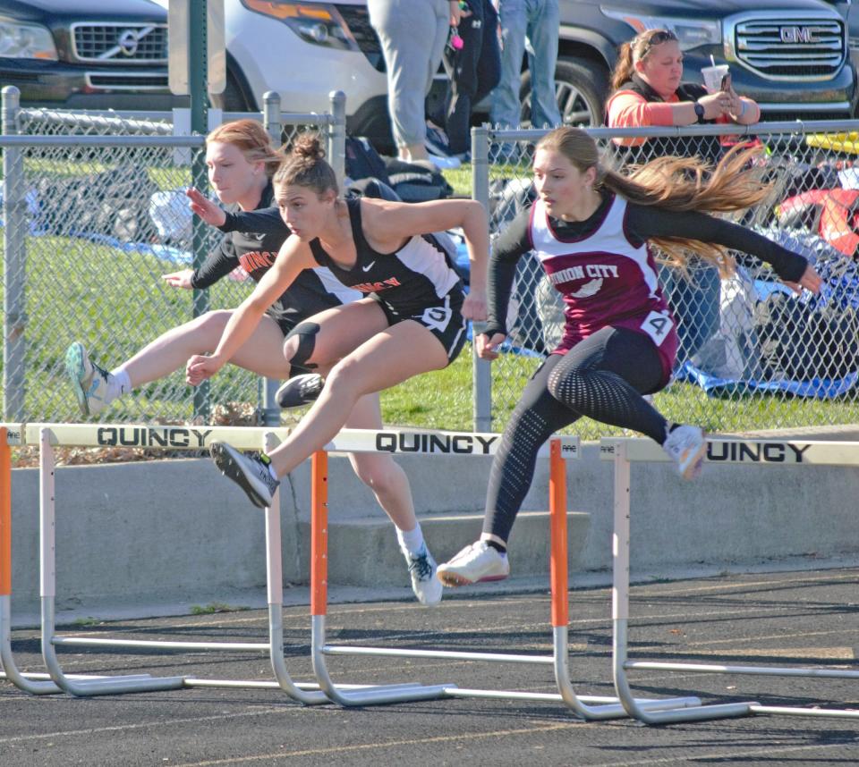 Quincy's Teegan Payne, Brookelynn Parker and Alaina Labar do battle in the 100 meter hurdles on Wednesday