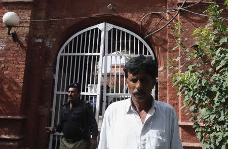 Muhammed Iqbal, 45, husband of the late Farzana Iqbal, waits for his relatives outside police station in Lahore May 31, 2014. REUTERS/Mohsin Raza