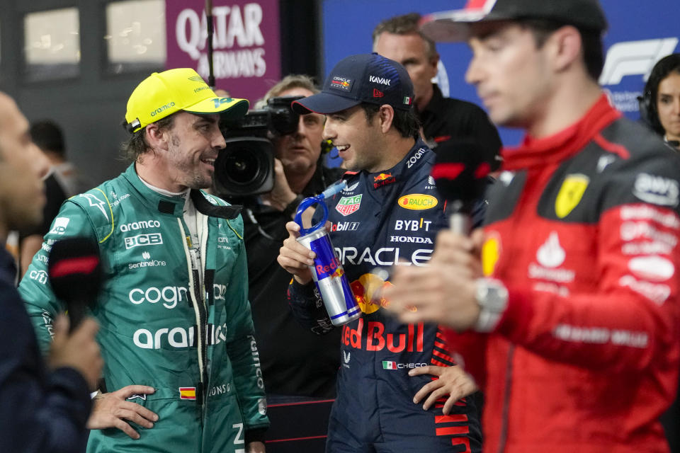 Red Bull driver Sergio Perez of Mexico, center, speaks with Aston Martin driver Fernando Alonso of Spain after the qualifying session ahead of the Formula One Grand Prix at the Jeddah corniche circuit in Jeddah, Saudi Arabia, Saturday, March 18, 2023. Sergio Perez stepped up for Red Bull to ensure the team started from the pole at the Saudi Arabian Grand Prix after a mechanical issue sidelined two-time defending world champion Max Verstappen. (AP Photo/Luca Bruno)