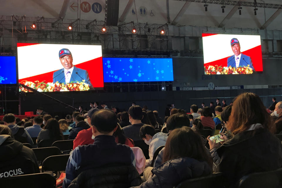 Screen shows Foxconn founder Terry Gou giving a speech as employees wearing masks attend the company's year-end gala in Taipei