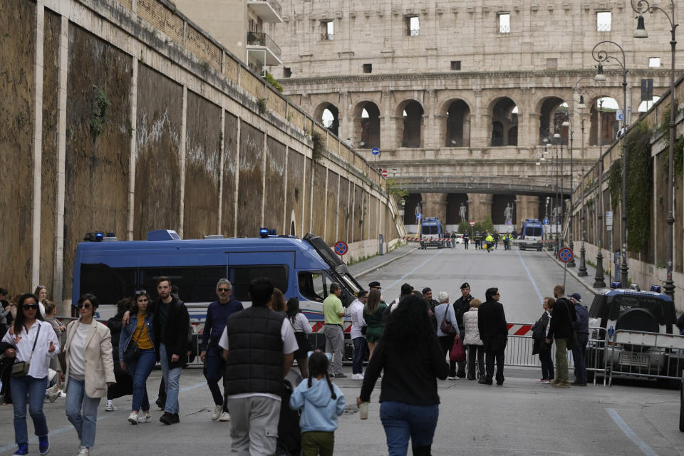 Policemen patrol prior to the start of the Via Crucis (Way of the Cross) torchlight procession at the Colosseum on Good Friday, in Rome, Friday, March 29, 2024. (AP Photo/Gregorio Borgia)