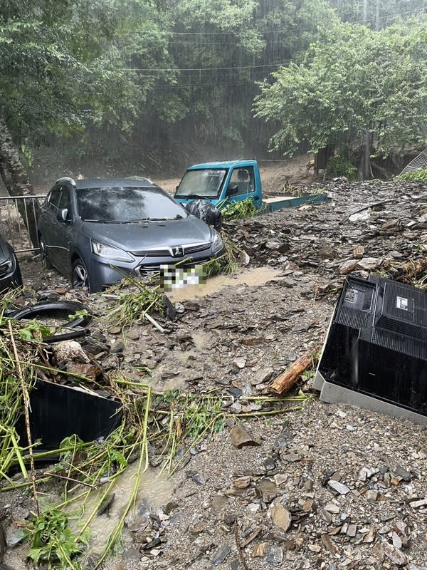 南投縣仁愛鄉豪雨不斷，4日多處多處道路坍方、出現泥流，都達村甚至有汽車遭土石流掩埋半個車身。 （中央社／民眾提供） 