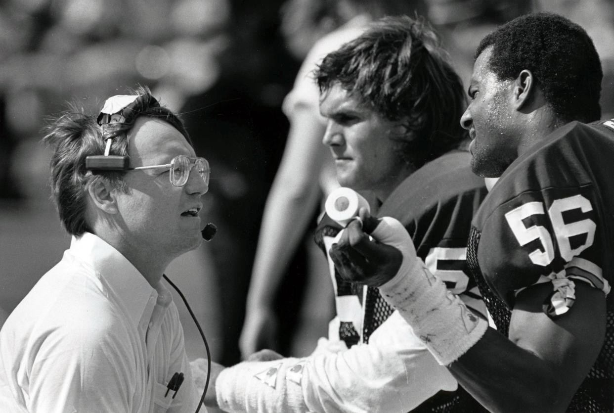 Cleveland Browns head coach Marty Schottenheimer talks to linebackers Clay Matthews (57) and Chip Banks (56) during the 1985 AFC Divisional Playoff Game against the Miami Dolphins at the Orange Bowl. Miami defeated Cleveland 24-21.