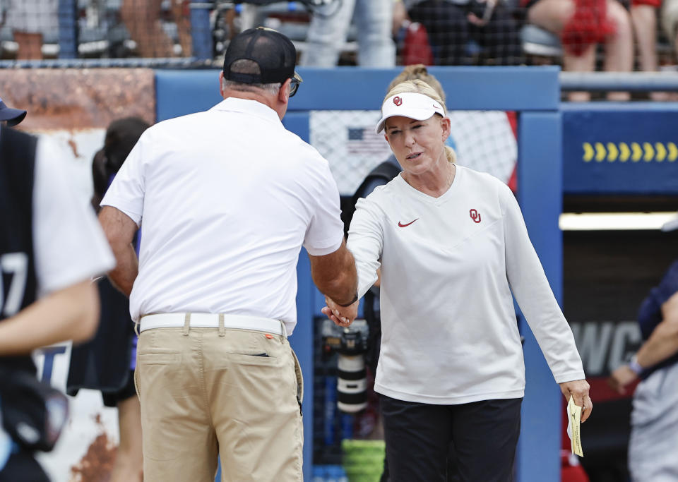 Oklahoma coach Patty Gasso, right, and Texas coach Mike White meet before Game 2 of the NCAA Women's College World Series softball championship series Thursday, June 6, 2024, in Oklahoma City. (AP Photo/Alonzo Adams)