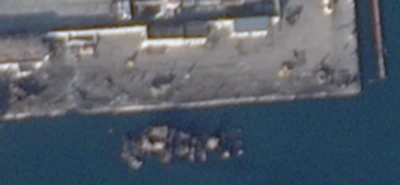 A close-up of the hulk of <em><em>Novocherkassk</em></em> and the immediate area around it, including the impact crater and indentation in the side of the pier, from the December 27 Planet Labs image. Other damage and debris are clearly visible. <em>PHOTO © 2023 PLANET LABS INC. ALL RIGHTS RESERVED. REPRINTED BY PERMISSION</em>