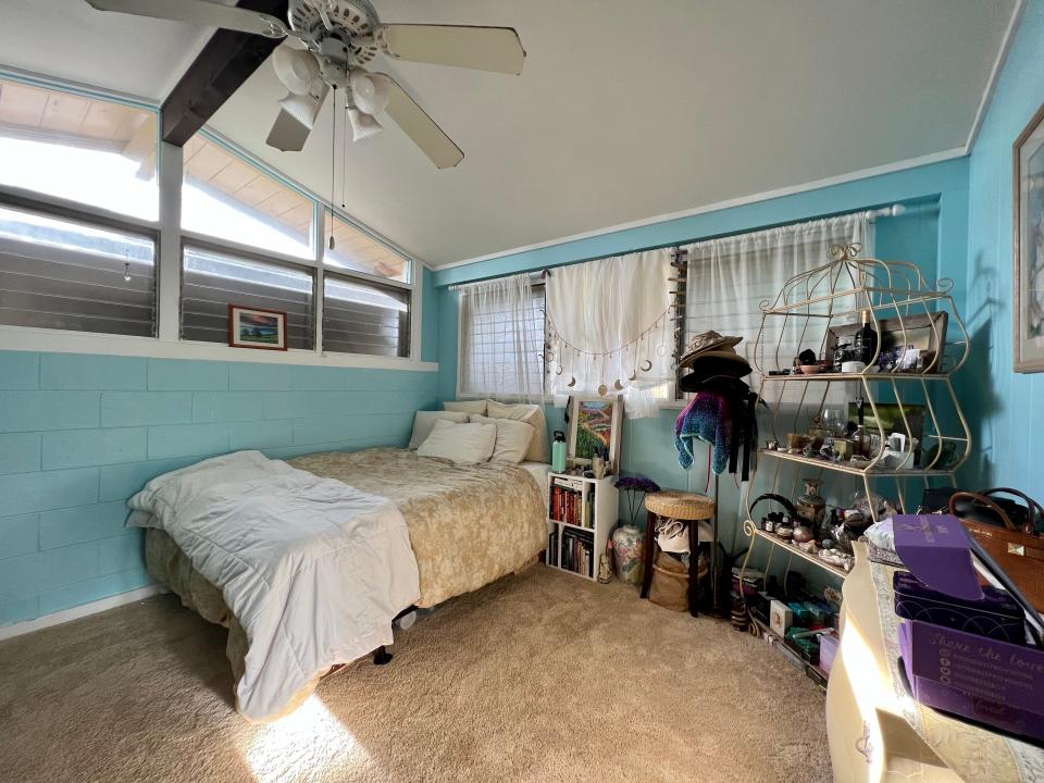 the writer's bedroom, bed against the wall and blue walls