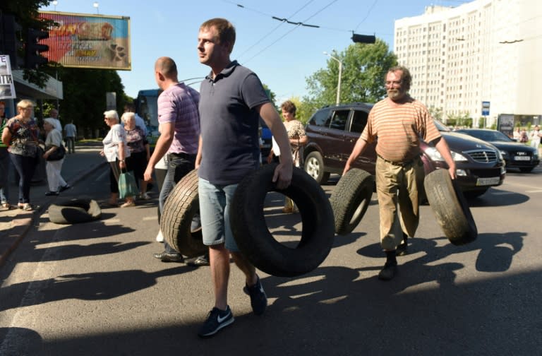 Residents collect tyres to block a road in the western Ukrainian city of Lviv during a protest against the local authorities