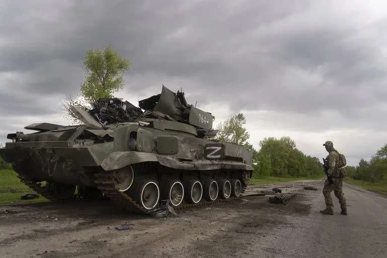 Un soldado ucraniano pasa junto a un tanque ruso destruido cerca de Kutuzivka, al norte de Járkiv, Ucrania, el 15 de mayo de 2022. (AP Foto/Mstyslav Chernov)