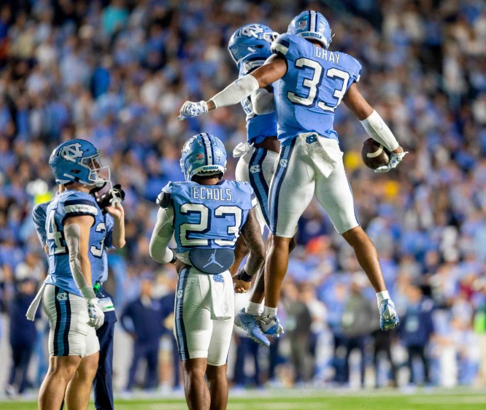 North Carolina’s Cedric Gray (33) and teammate Tayon Holloway (20) celebrate Gray’s interception of Miami quarterback Tyler Van Dyke in the third quarter on Saturday, October 14, 2023 at Kenan Stadium in Chapel Hill, N.C.