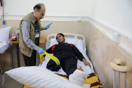 A doctor helps a patient during his rehabilitation in a hospital south of Mosul, Iraq, April 11, 2017. Picture taken April 11, 2017. REUTERS/Marko Djurica