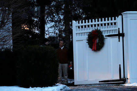 Men are seen at the gate to the home of former U.S. President Bill Clinton and former Democratic presidential candidate Hillary Clinton after firefighters were called to put out a fire at the property in Chappaqua, New York, U.S., January 3, 2018. REUTERS/Mike Segar