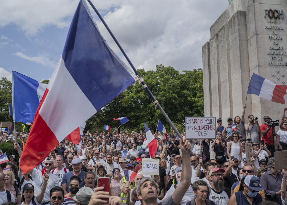 Thousands of protesters gather at Place Trocadero near the Eiffel Tower attend a demonstration in Paris, France, Saturday July 24, 2021, against the COVID-19 pass which grants vaccinated individuals greater ease of access to venues. (AP Photo/Rafael Yaghobzadeh)