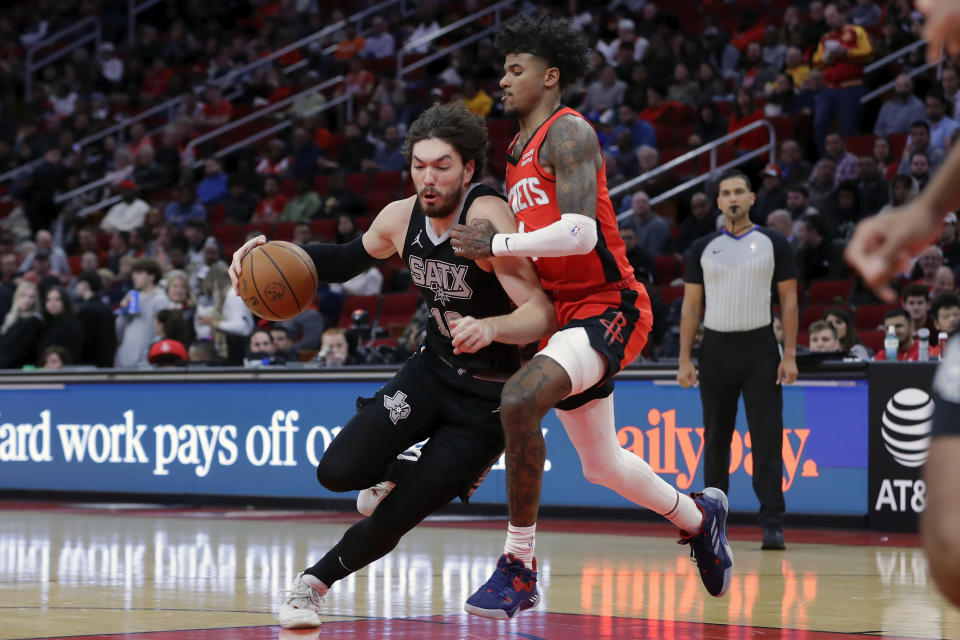 San Antonio Spurs forward Cedi Osman, left, drives around Houston Rockets guard Jalen Green, right, during the first half of an NBA basketball game, Monday, Dec. 11, 2023, in Houston. (AP Photo/Michael Wyke)