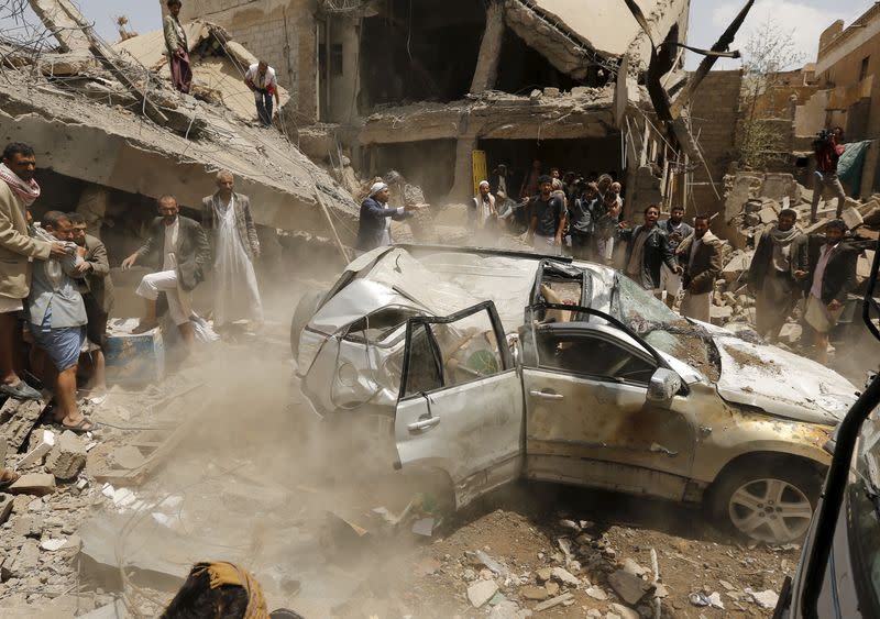 FILE PHOTO: A car falls while being lifted by a crane at the site of a Saudi-led air strike in Yemen's capital Sanaa