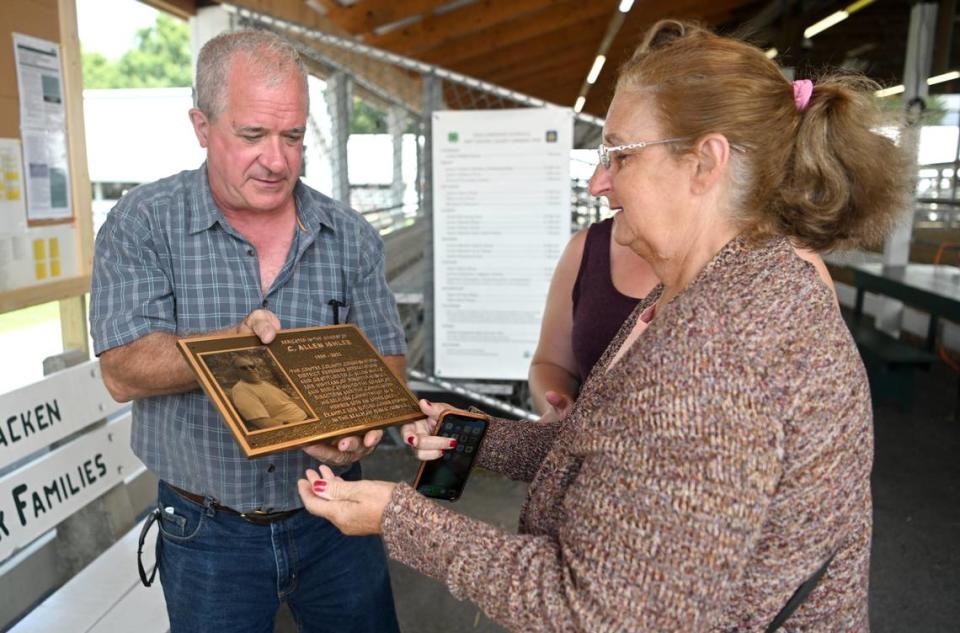 Steve Dershem shows Holly Ishler the plaque honoring her late husband C. Allen Ishler at the Centre County Grange Encampment and Fair on Friday, Aug. 18, 2023.  The plaque donated by the Centre County Conservation District was hung in the judging arena. 