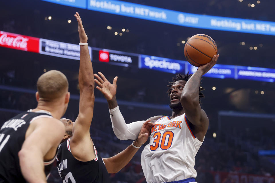 New York Knicks forward Julius Randle, right, shoots under pressure from Los Angeles Clippers forward Nicolas Batum, center, during the first half of an NBA basketball game Saturday, March 11, 2023, in Los Angeles. (AP Photo/Ringo H.W. Chiu)