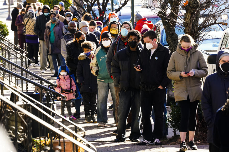 City residents wait in a line extending around the block to receive free at-home rapid COVID-19 test kits in Philadelphia, Monday, Dec. 20, 2021. U.S. health officials are calling on Americans to get tested for COVID-19 before they travel and gather for the holidays. But what should you do if you test positive? (AP Photo/Matt Rourke)