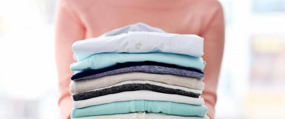 Woman hold clothes pile, close up