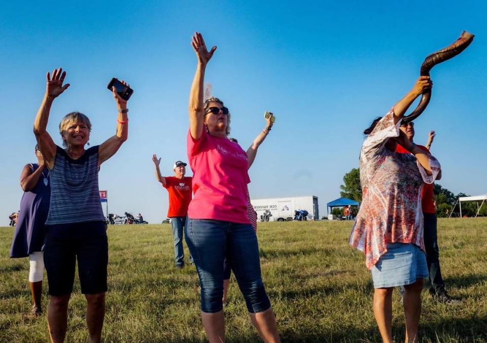 Attendants at the Prayer at the Heart of America event in Lebanon, Kansas, lift up their hands as others pray over names on cards, Friday, July 22, 2021. Those in attendance could write names of those who they knew needed prayer on the cards.