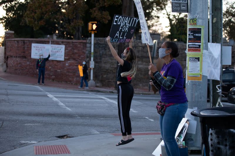 Protesters hold signs on equality as they demonstrate at an intersection near Downtown in Atlanta