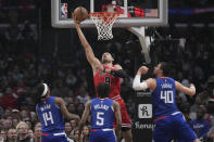 Chicago Bulls center Nikola Vucevic (9) scores over Los Angeles Clippers guard Terance Mann (14), guard Bones Hyland (5) and center Ivica Zubac (40) during the first half of an NBA basketball game Monday, March 27, 2023, in Los Angeles. (AP Photo/Marcio Jose Sanchez)