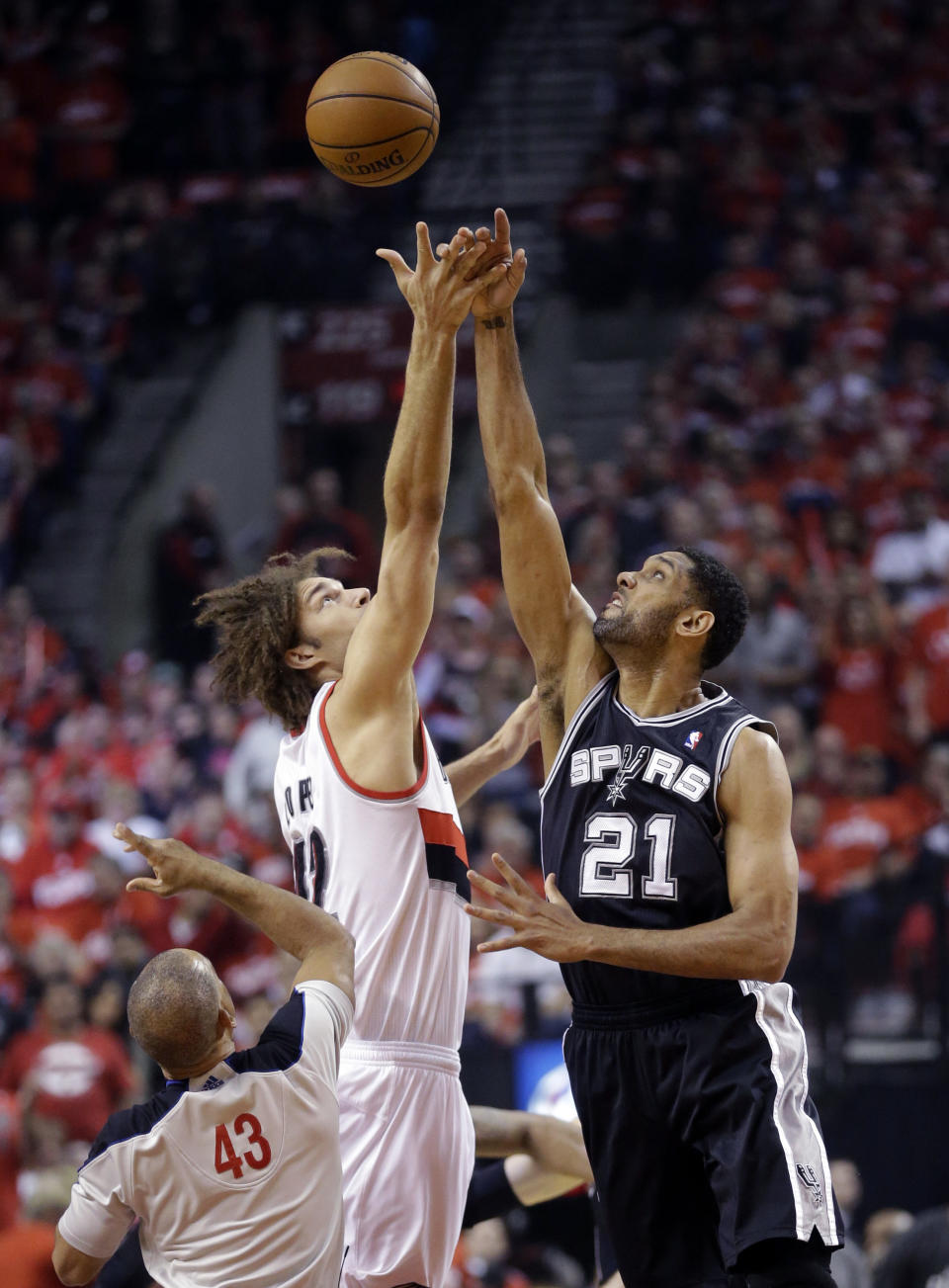 Portland Trail Blazers' Robin Lopez, left, and San Antonio Spurs' Tim Duncan (21) battle for the tipoff in the first quarter during Game 3 of a Western Conference semifinal NBA basketball playoff series Saturday, May 10, 2014, in Portland, Ore. (AP Photo/Rick Bowmer)