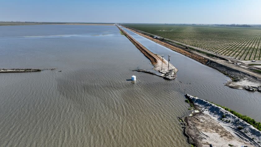 Corcoran, CA, Monday, June 5, 2023 - An aerial view of the breached Boyette Levee, left, that flooded hundreds of acres of Makram Hanna's pistachio orchard. The breach allowed water to flow from the surging Tulare Lake, left foreground, flooding the land owned by a conglomerate led by Hanna. (Robert Gauthier/Los Angeles Times)