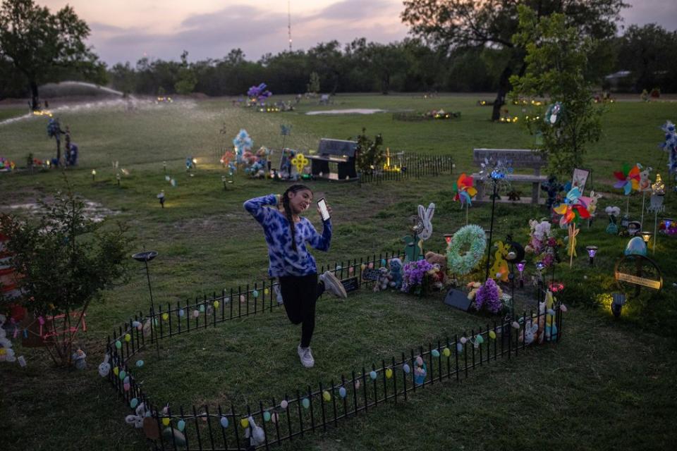 Caitlyne Gonzales, who lost many of her friends in the shooting, sang and danced to Taylor Swift songs at Jacklyn Cazares' grave in Uvalde, Texas, on April 19. One year after 19 children and two teachers were killed at Robb Elementary, the cemetery where most of the victims are buried has become an anchor in their families' lives.<span class="copyright">Tamir Kalifa—The New York Times/Redux</span>