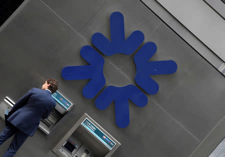 FILE PHOTO: A customer uses an ATM at a branch of RBS (Royal Bank of Scotland) bank in the City of London financial district in London September 4, 2017. REUTERS/Toby Melville/File Photo