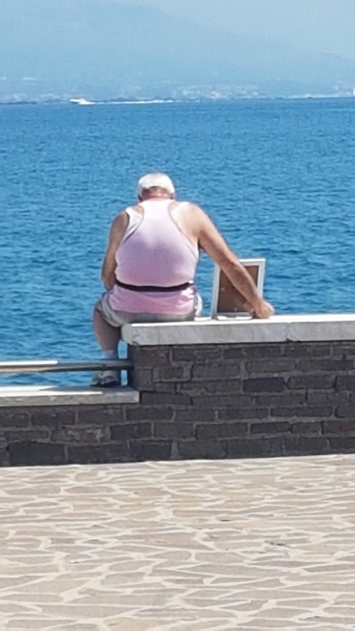 A 72-year-old widower has taken his wife’s portrait to the pier where they fell in love every morning since she died seven years ago. (Photo: Giorgio Moffa)