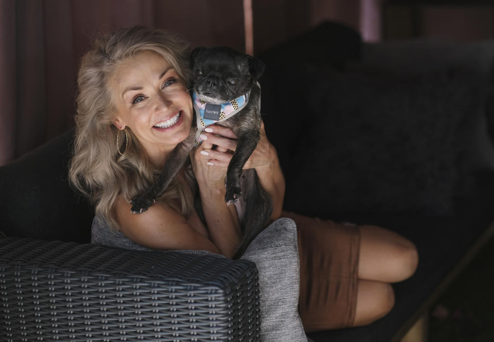 Model Kathy Jacobs poses for a portrait with her pug Thumbelina at her home in Calabasas, Calif. on Friday, July 17, 2020. Jacobs has made her Sports Illustrated swimsuit issue debut at age 56. The 2020 Sports Illustrated Swimsuit issue is online and on newsstands Tuesday. (AP Photo/Chris Pizzello)