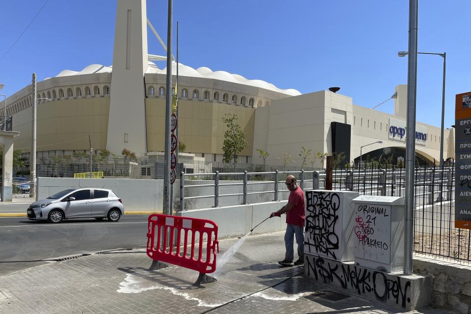 A municipal worker clears blood from the sidewalk outside OPAP Arena, after overnight clashes between rival supporters in Nea Philadelphia suburb, in Athens, Greece, Tuesday, Aug. 8, 2023. European governing soccer body UEFA says it has postponed a Champions League qualifying game between AEK Athens and Croatia's Dinamo Zagreb scheduled for Tuesday because of the violence. Eight fans were injured while Greek police said Tuesday they had made 88 arrests, mostly of Croatian supporters. (AP Photo/Thanassis Stavrakis)