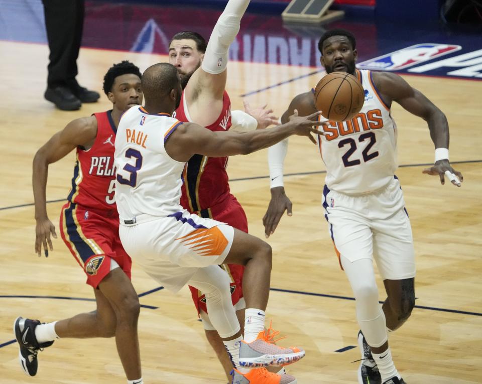 Apr 22, 2022; New Orleans, Louisiana, U.S.;  Phoenix Suns guard Chris Paul (3) passes the ball to center Deandre Ayton (22) while defended by New Orleans Pelicans center Jonas Valanciunas (17) during Game 3 of the Western Conference playoffs. Mandatory Credit: Michael Chow-Arizona Republic