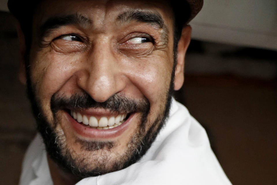 In this June 17, 2019, photo, Diaa Alhanoun, a Syrian refugee chef, smiles broadly while grinding meat in preparation for the 2019 Refugee Food Festival at Porsena, an East Village Italian restaurant, in New York. A festival veteran, Alhanoun participated for his second year along with other refugee chefs from Eat Offbeat who served meals at other local New York restaurants. Eat Offbeat is a refugee-staffed catering company where Alhanoun worked before opening his own restaurant. (AP Photo/Kathy Willens)