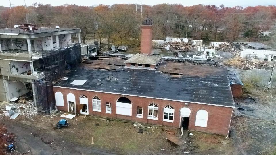 A brick building with a black roof damaged by fire