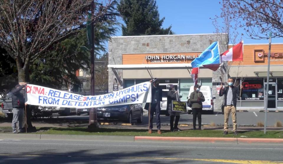溫哥華的維吾爾團體前往卑詩省省長賀謹的辦公室遞交抗議聲明，並在辦公室前高舉標語進行示威。(央廣特約記者張雅如攝)