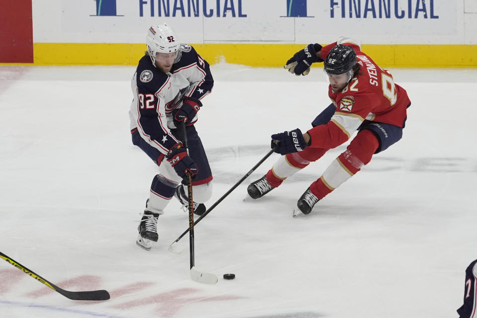 Columbus Blue Jackets left wing Alexander Nylander (92) gets control of the puck as Florida Panthers center Kevin Stenlund (82) defends during the first period of an NHL hockey game, Thursday, April 11, 2024, in Sunrise, Fla. (AP Photo/Marta Lavandier)