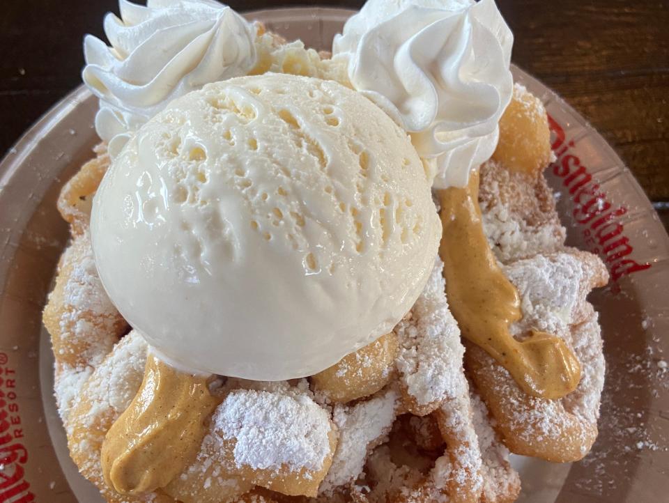 plate of funnel cake with whipped cream and ice cream at disneyland