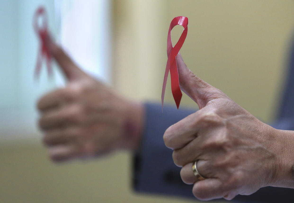 Philippine health officials pose with a red ribbon, the symbol of support and awareness for those living with HIV, on their thumbs to mark World Aids Day on 1 December, 2017, in Manila, Philippines. (PHOTO: AP)