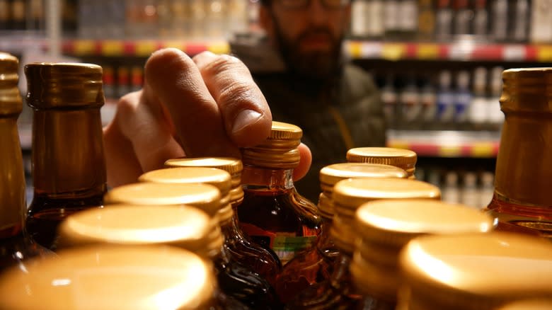 man selecting liquor bottle