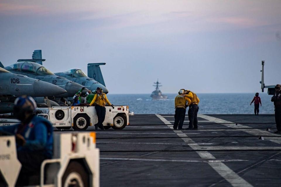 US Navy sailors embrace on the flight deck aboard USS Dwight D. Eisenhower in the Gulf of Aden.