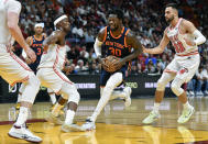 New York Knicks forward Julius Randle (30) drives on Miami Heat forward Jimmy Butler (22) and guard Max Strus (31) during the first half of an NBA basketball game, Wednesday, March 22, 2023, in Miami, Fla. (AP Photo/Michael Laughlin)